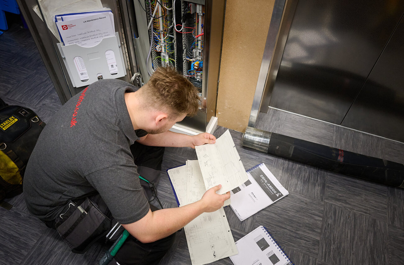 Aaron binks, senior lift technician at MV Lifts reading wiring diagrams fixing a fault